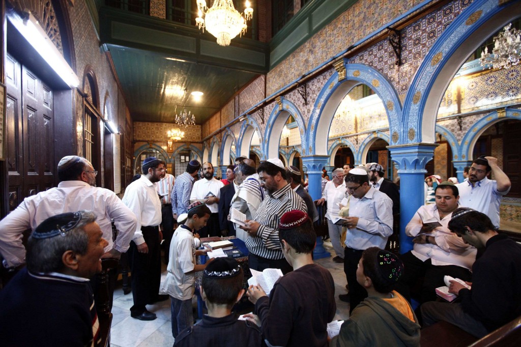 Jewish men pray inside the blue-tiled El Ghriba synagogue on the Tunisian island of Djerba following a wedding ceremony