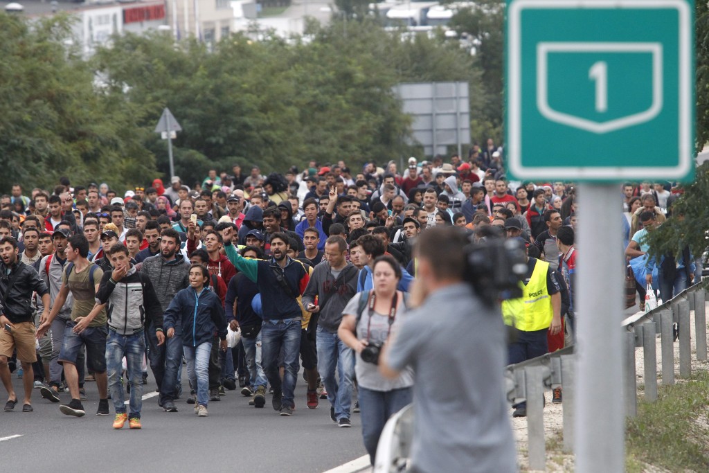 Budaörs, 2015. szeptember 5. Nyugat-Európába tartó illegális bevándorlók vonulnak az M1-es M§-ás lehajtójánál 2015. szeptember 5-én. Az ország több pontjáról is gyalog indultak útnak Bécs felé a Magyarországon tartózkodó migránsok azt követõen, hogy az éjjel Ausztria és Németország beengedte a bevándorlókat, akiket a kormány buszokkal szállított a határra. MTI Fotó: Szigetváry Zsolt