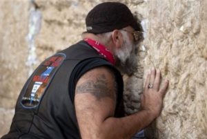 A member of a group of U.S. bikers, participating in 'Run for the Wall Israel', touches the stones of the Western Wall, the holiest site where Jews can pray, in Jerusalem's old city, Sunday, Nov. 6, 2011. The group of motorcyclists from the United States, including Evangelical pastors and military veterans, holds tours in support of soldiers. (AP Photo/Sebastian Scheiner)