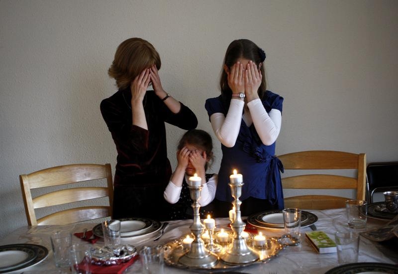 Female members of the Nogradi family light candles at the Sabbath in their home in Budapest November 30, 2012. It is only relatively recently that Hungary's Jews have celebrated their identity as openly as they did when Europe's largest synagogue was built in Budapest in the 1850s. Now they are determined not to allow a political climate in which they have to defend that identity or even suppress it. Although anti-Semitism has not yet led to serious physical confrontations, hate crimes have included desecration of Jewish cemeteries and a verbal attack in Budapest on 90-year-old former Chief Rabbi Joseph Schweitzer. Picture taken November 30, 2012. To match HUNGARY-JEWS/ REUTERS/Bernadett Szabo (HUNGARY - Tags: RELIGION POLITICS SOCIETY) - RTR3BMUH