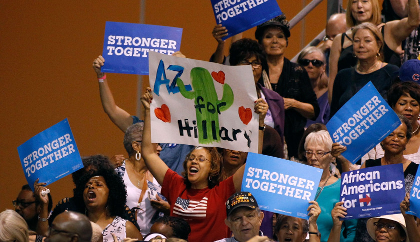 PHOENIX, AZ - OCTOBER 20:  Supporters for presidential nominee Hillary Clinton hold up signs and cheer as first lady Michelle Obama speaks at an Arizona Democratic Party Early Vote rally on October 20, 2016 in Phoenix, Arizona.  (Photo by Ralph Freso/Getty Images)