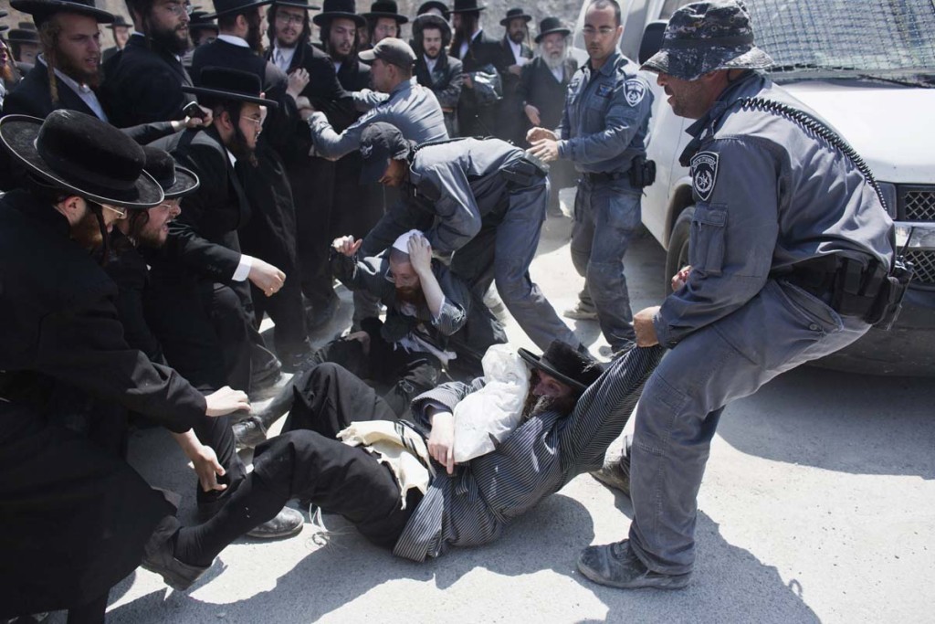 Israeli policemen drag ultra-Orthodox protesters during clashes in the town of Beit Shemesh, near Jerusalem August 12, 2013. An Israeli police spokesperson said some 21 ultra-Orthodox protesters were detained on Monday in the town during clashes with police after a group of them broke into a construction site to prevent work from taking place at the site they believe contains ancient graves. REUTERS/Nir Elias (ISRAEL - Tags: POLITICS RELIGION CIVIL UNREST) ORG XMIT: JER10
