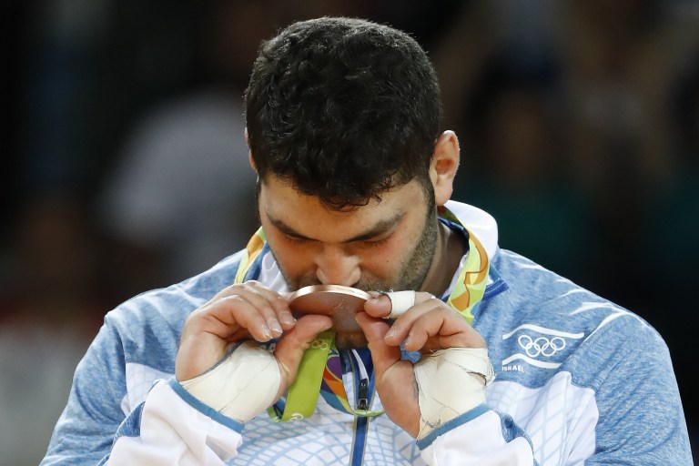 Bronze medallist Israel's Or Sasson celebrates on the podium of the men's +100kg judo contest of the Rio 2016 Olympic Games in Rio de Janeiro on August 12, 2016. / AFP PHOTO / Jack GUEZ