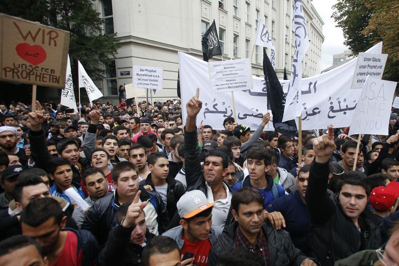 Austrian Muslims carry banners and shout slogans during a protest against a film made in the U.S. and cartoons published by a French magazine that denigrate Islam's Prophet Mohammad, in Vienna September 22, 2012.   REUTERS/Leonhard Foeger   (AUSTRIA - Tags: CIVIL UNREST RELIGION) - RTR38A9P